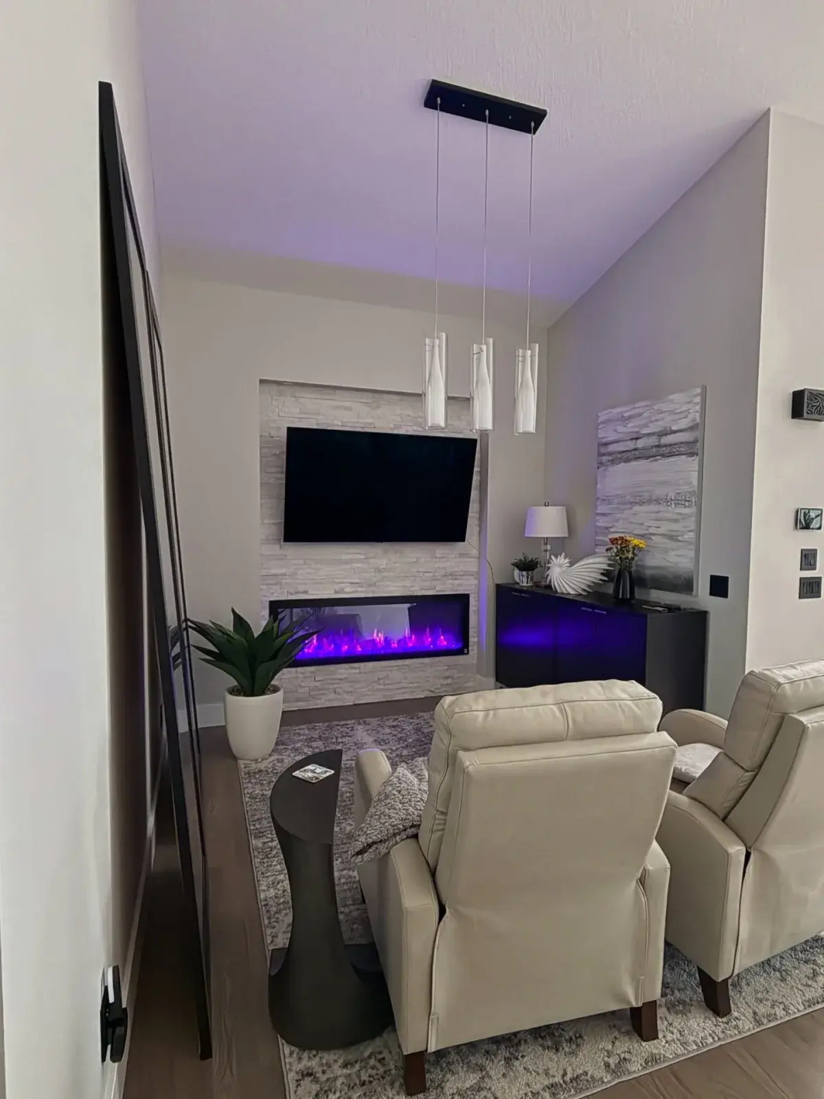 Modern living room with a stone LED fireplace feature wall, freshly painted by Chamos Painting